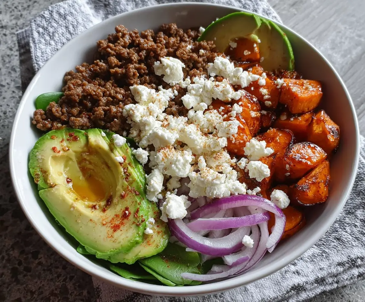 Hearty ground beef power bowl topped with fresh avocado slices and cottage cheese, a healthy and protein-rich meal option.