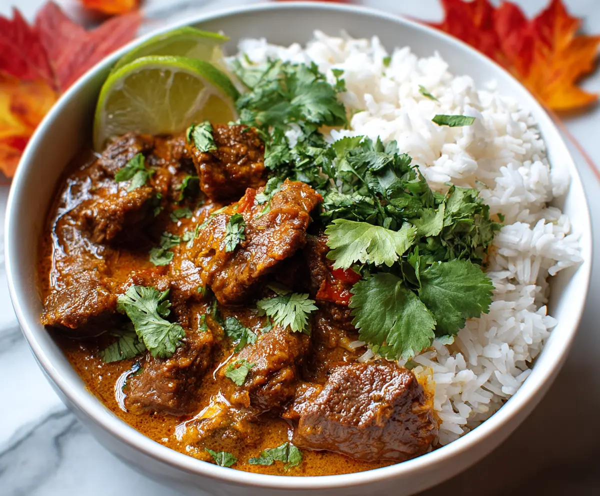 Delicious slow cooker beef coconut curry served with fresh herbs and rice