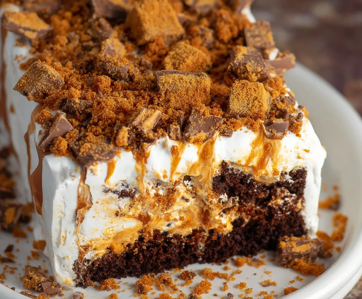 Layered Butterfinger Cake with chocolate, peanut butter, and butterfinger candies for a decadent dessert.