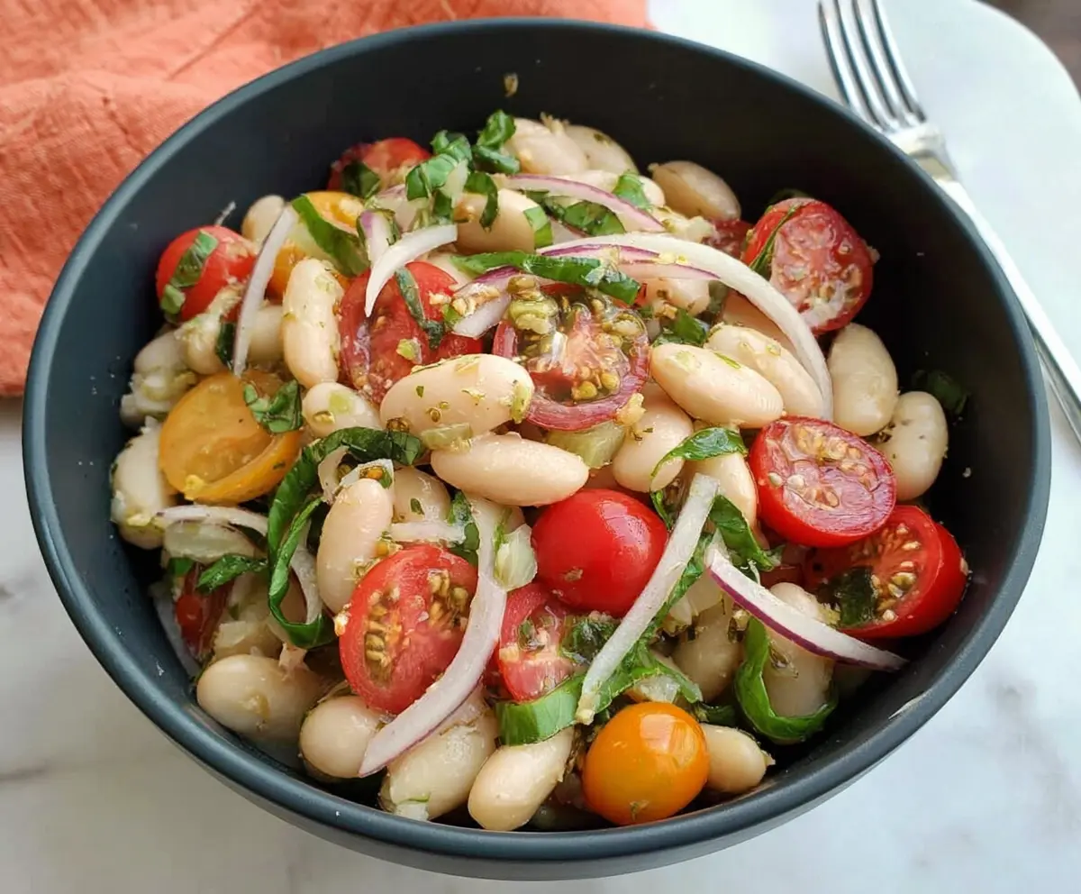 Fresh Italian White Bean Salad with cherry tomatoes, herbs, and olive oil in a rustic bowl.